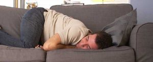 Man laying on couch fearing his business is going to fail due to COVID.